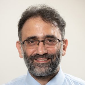 Headshot of smiling middle-aged man with beard wearing glasses